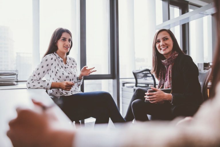 Group of women sitting and talking together in office meeting