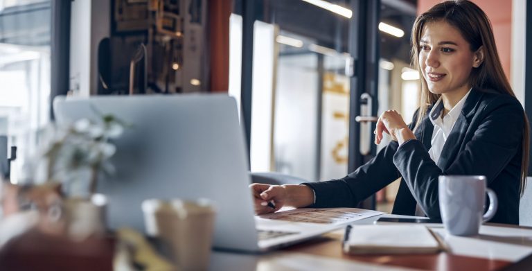 Draftswoman sitting at the desk with technical drawings on it